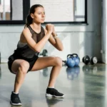 Woman doing jump squats in living room